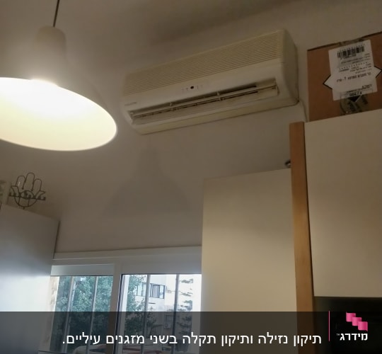 מזגן מותקן על קיר מעל ארון במטבח
